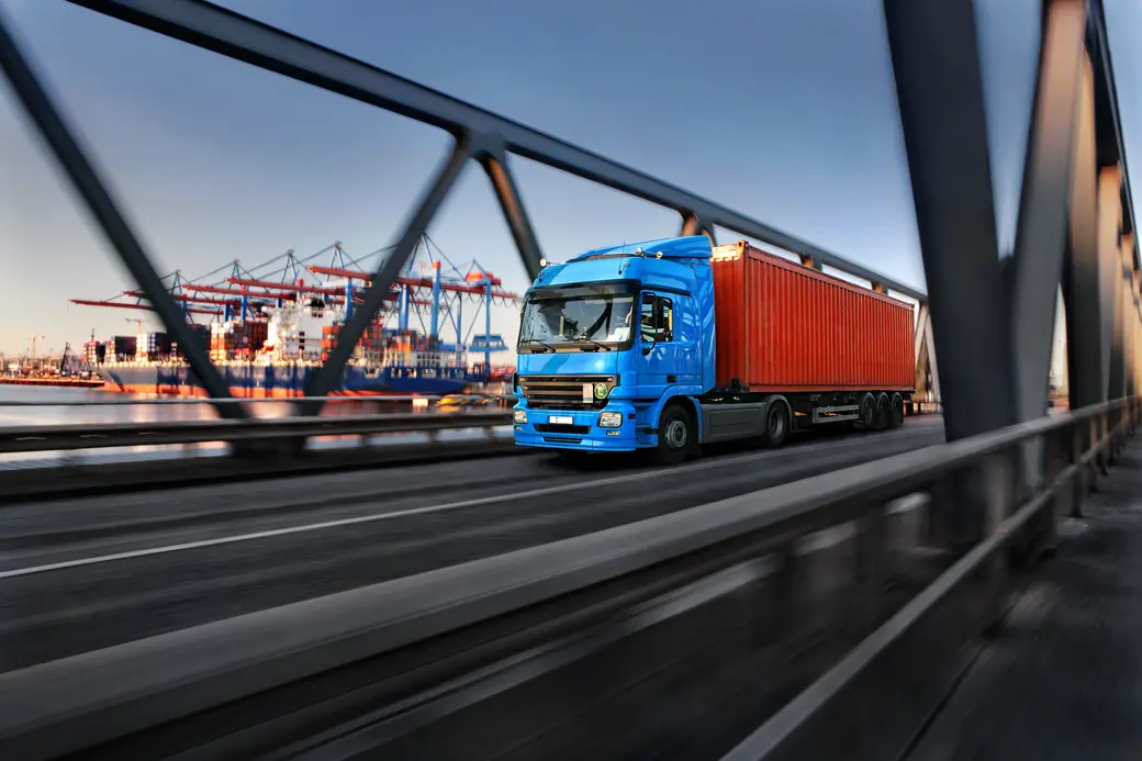 Lkw fährt über eine Brücke am Containerhafen
