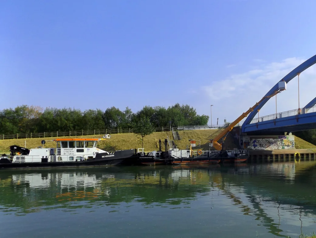 Schwimmende Hebebühne Von einem Schiffsrumpf wird eine Hebebühne an eine Brücke ausgefahren
